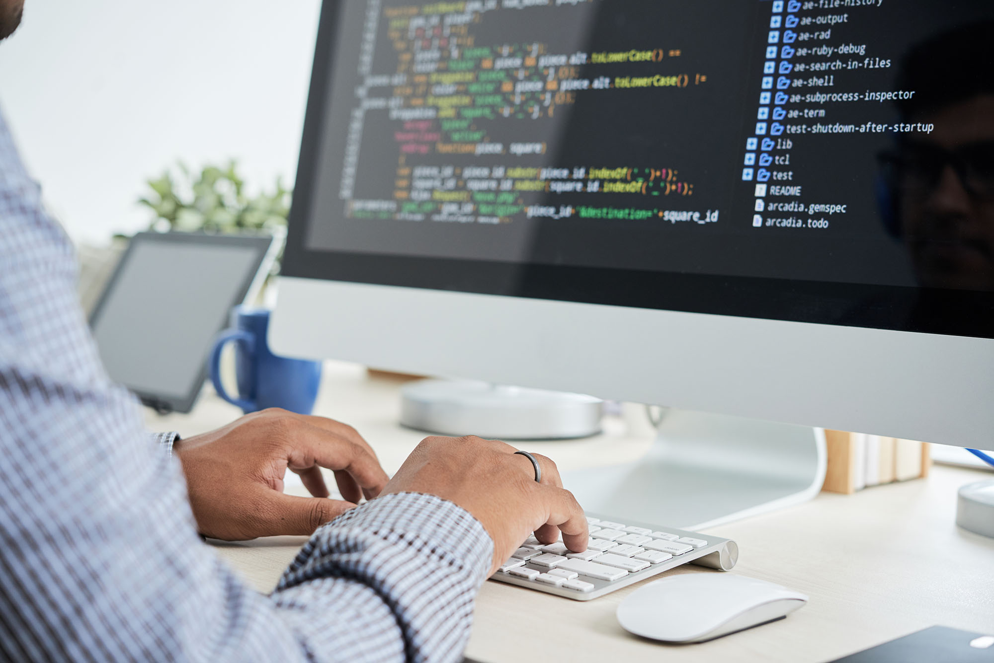 Photo of a software engineer writing code on a computer.